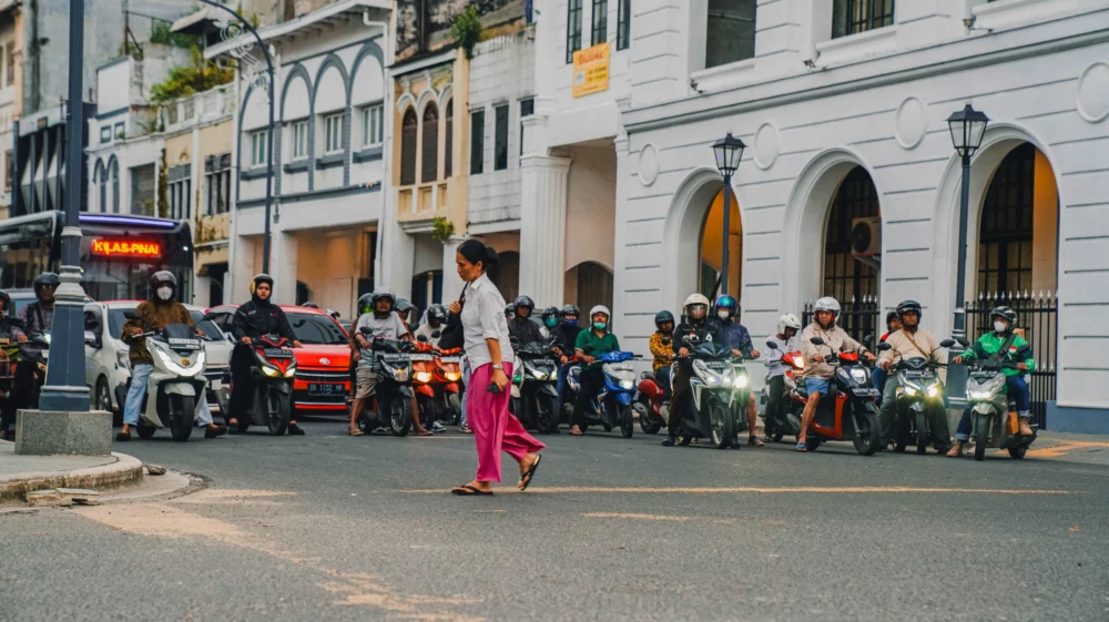 A pedestrian crossing an intersection in Medan.