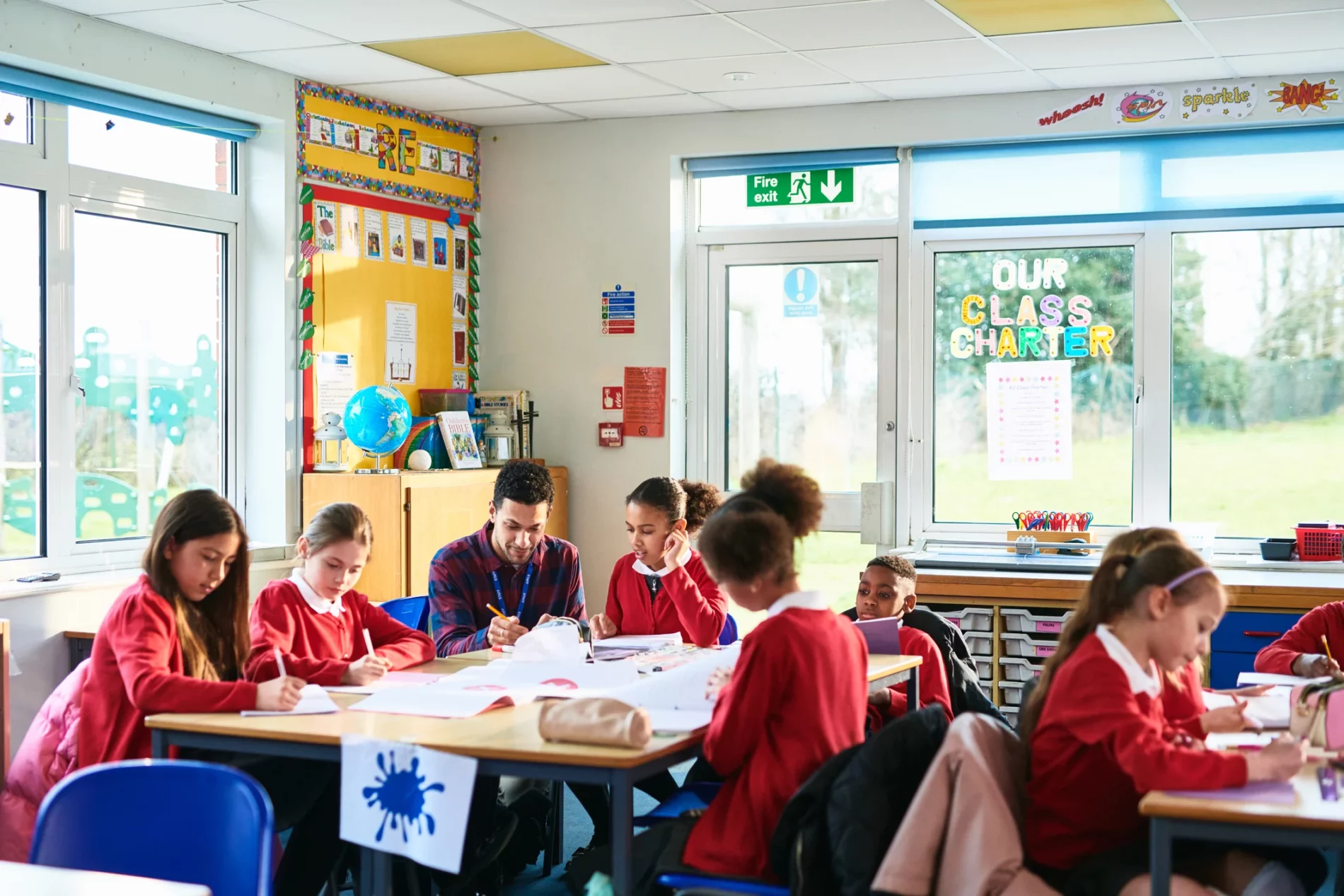 Teacher and primary school children in a classroom.