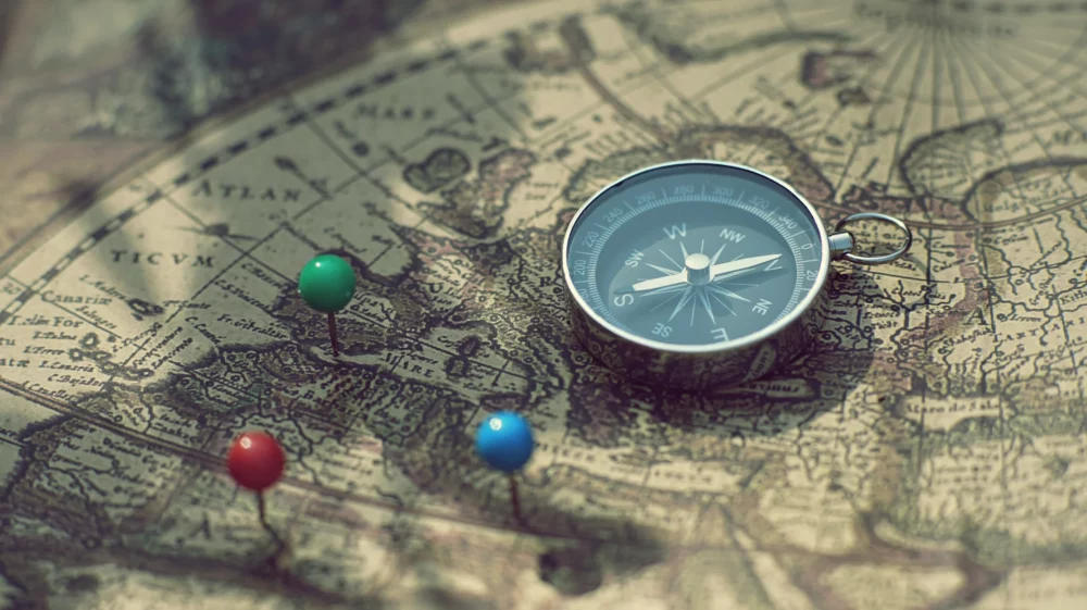 Compass and pin point marking with vintage world map background.