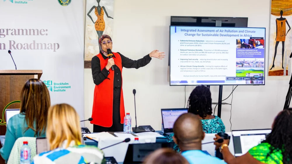 Martina Otto, Head of Secretariat at the Climate and Clean Air Coalition (CCAC), presents findings from the Integrated Assessment of Air Pollution and Climate Change for Sustainable Development in Africa during the ACAP Roadmap meeting in Accra, Ghana. Participants are seated and engaged, with the assessment summary displayed on a screen.
