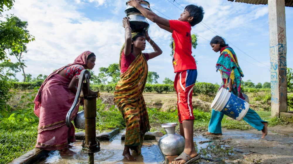 People collecting water from well in small village, Bangladesh