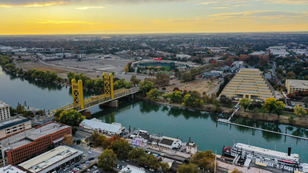 River between two cities with a yellow bridge connecting them