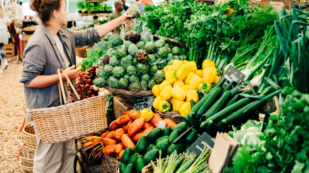 Woman choosing fruits and vegetables at farmers market