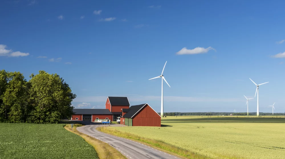 Wind turbines surrounding a Swedish farmhouse