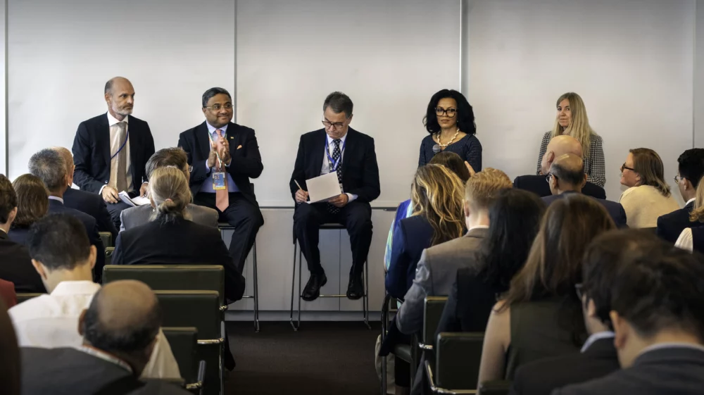 Panel of five speakers addressing an audience at a climate-related event during New York Climate Week, with participants seated and listening attentively.