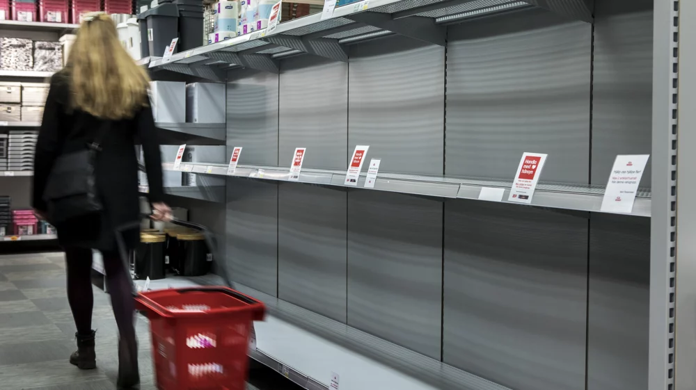 Woman in Swedish super market with empty shelves.