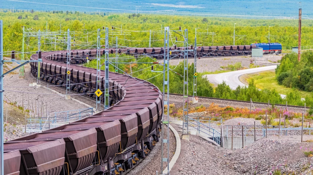 Loaded iron ore train in Arctic Circle extreme terrain hauled by electric locomotives