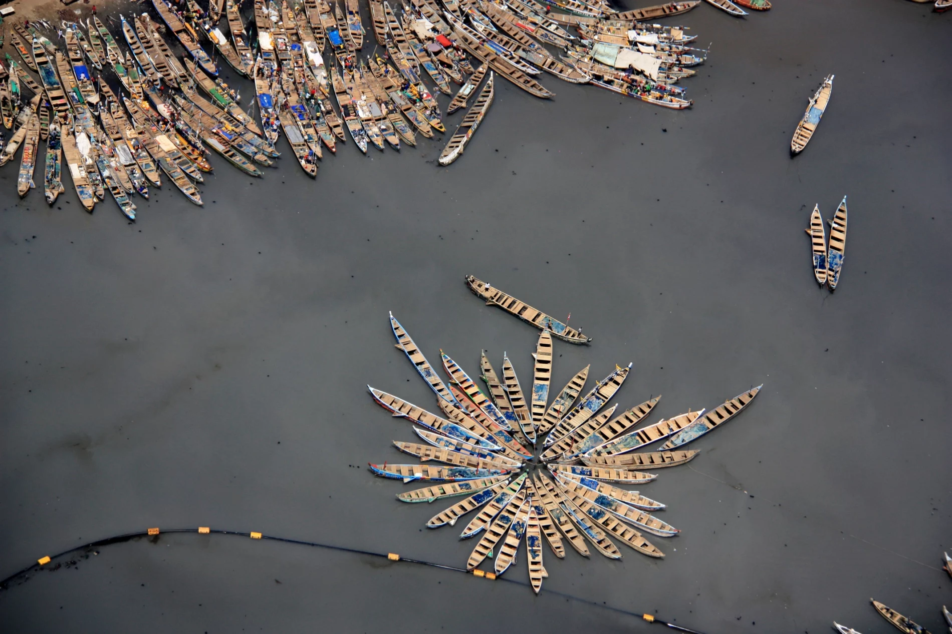 Fishing boats waiting while fishermen sell the catch of the day on the market