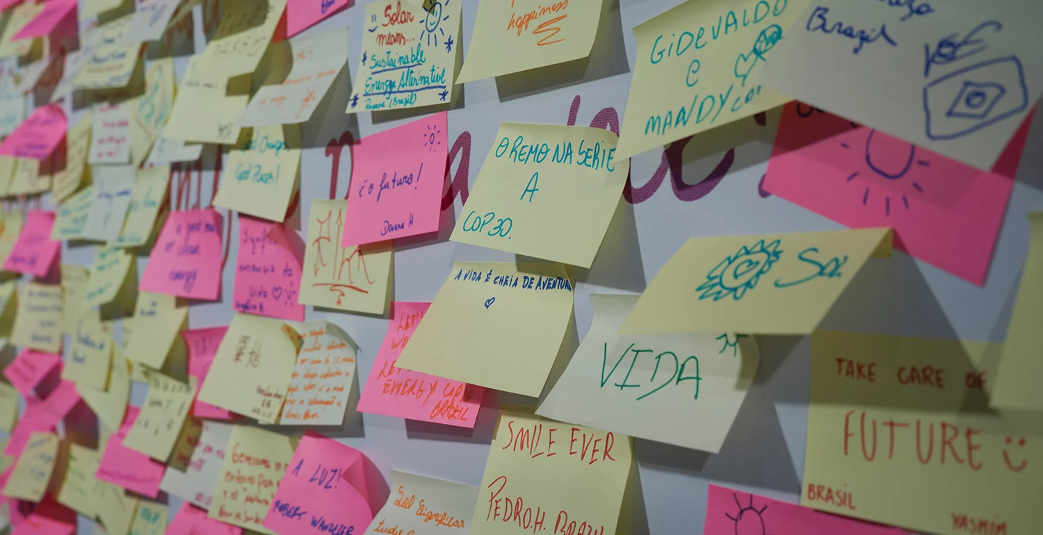 A wall covered in colourful sticky notes with handwritten messages.