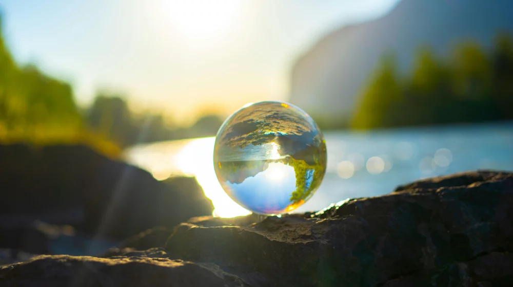 A Glass ball surrounded by nature. In the back you can see the river Inn