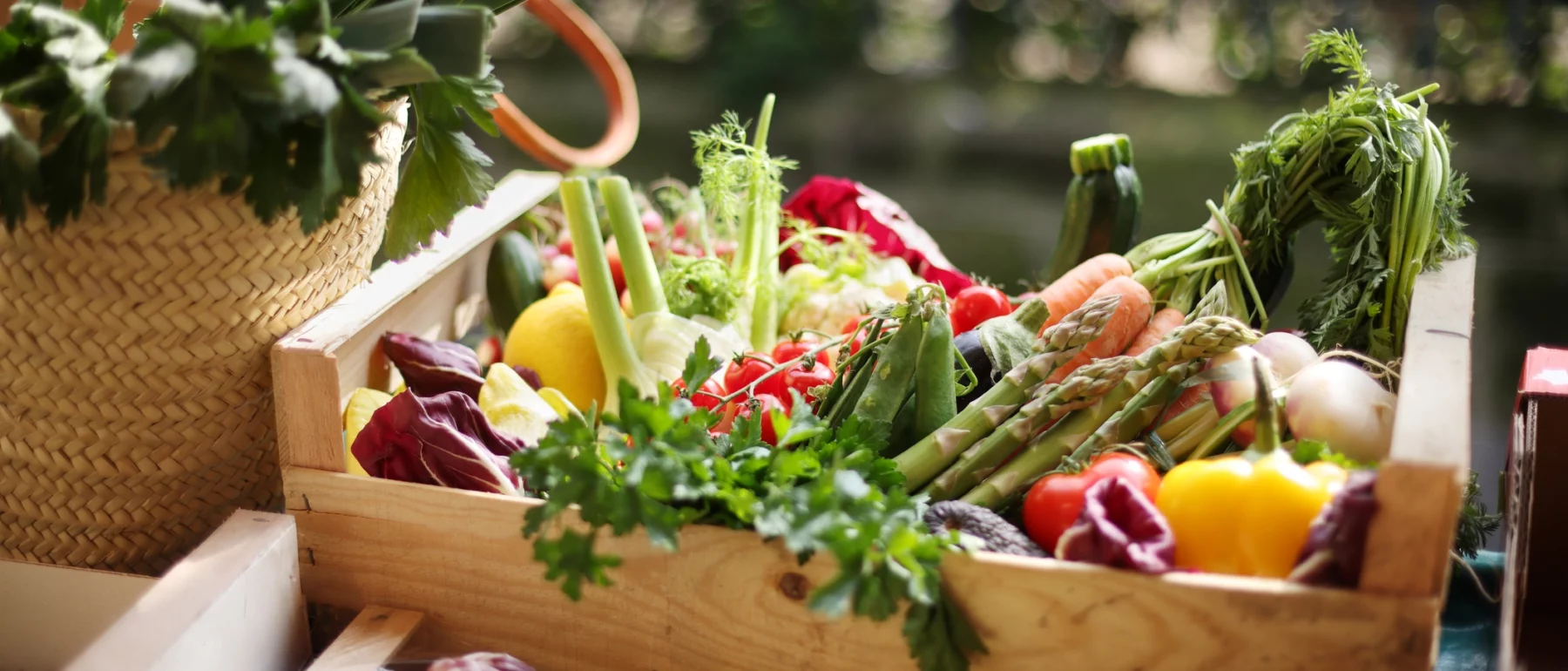 Many different colourful fresh vegetables in the wooden box