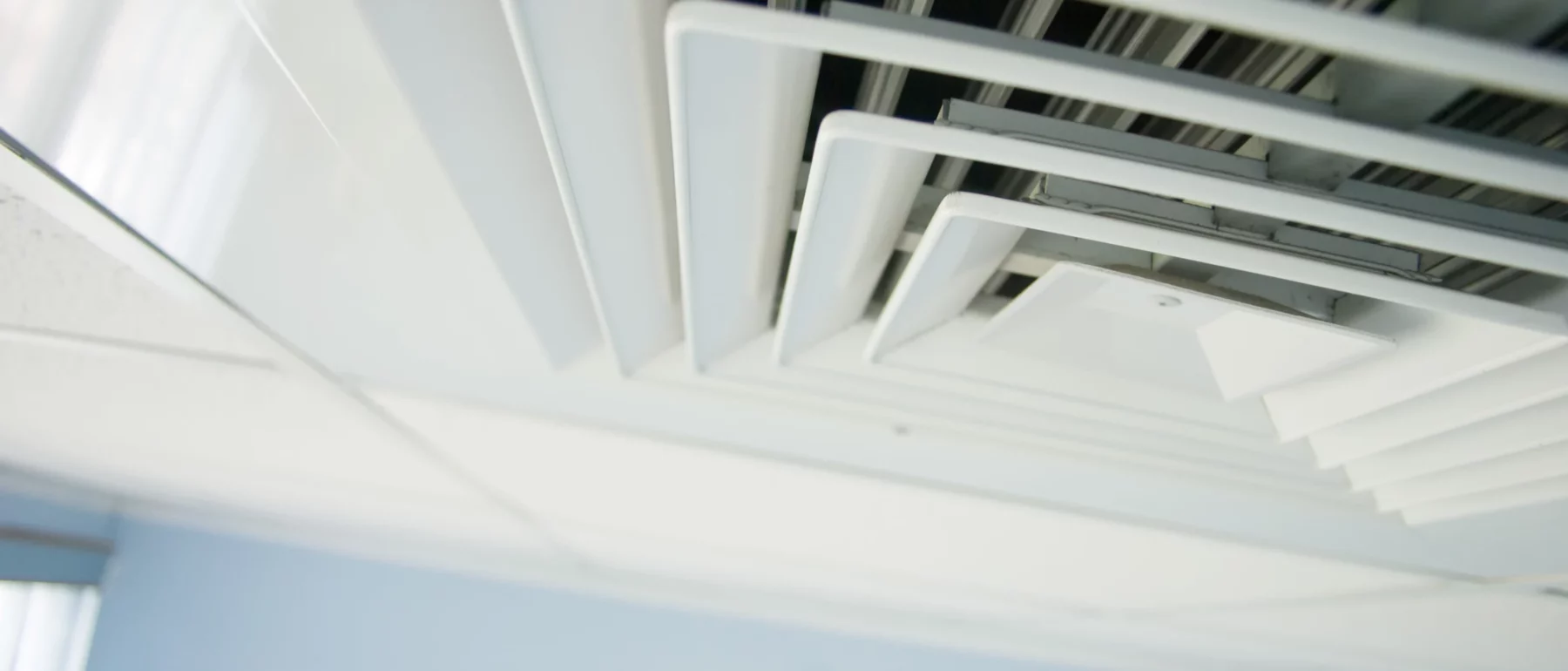 Close up of air condition vent in office ceiling.
