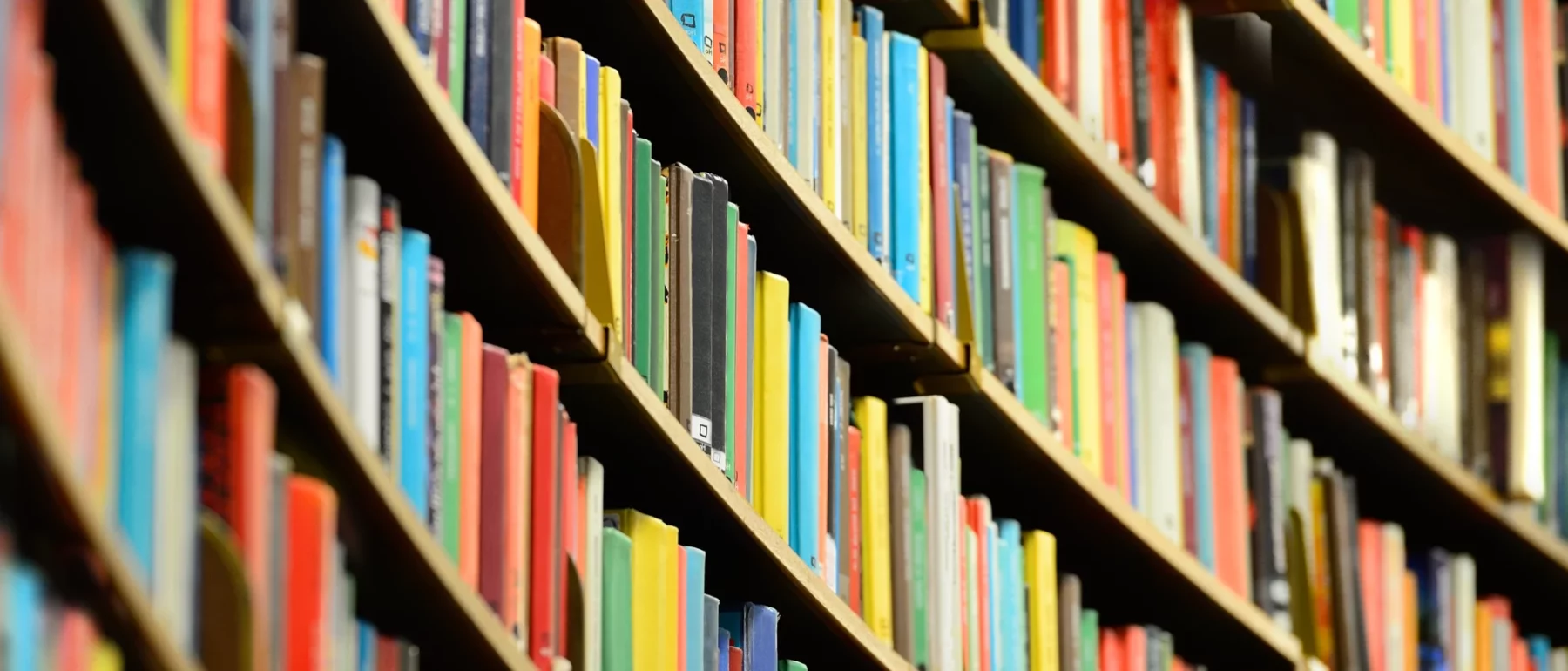 Rows of colorful books on curved library shelves.
