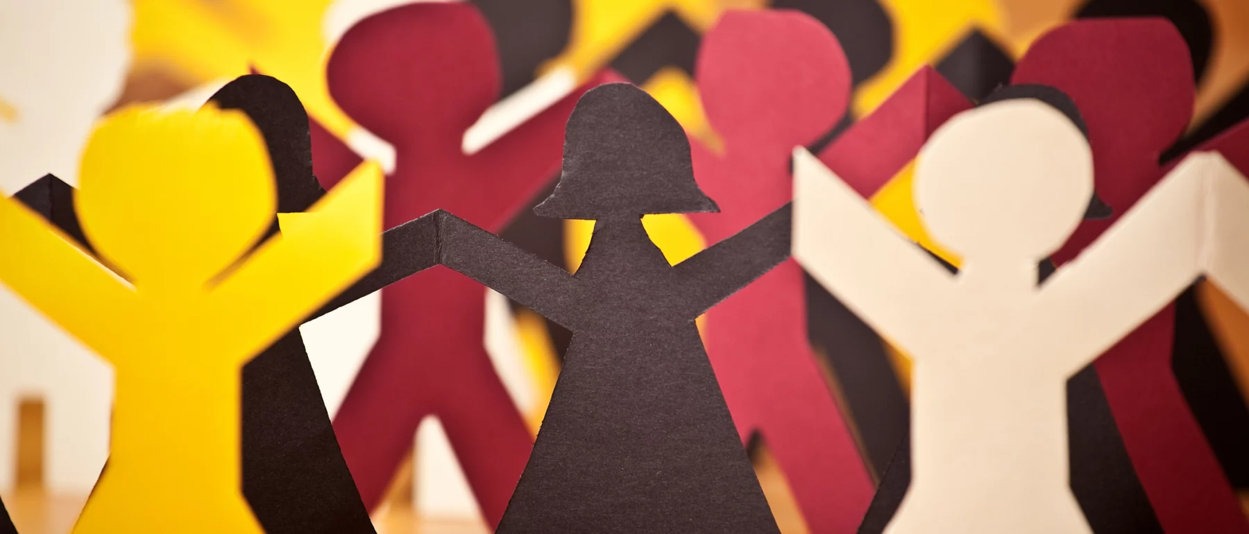 A group of multi-colored paper people.