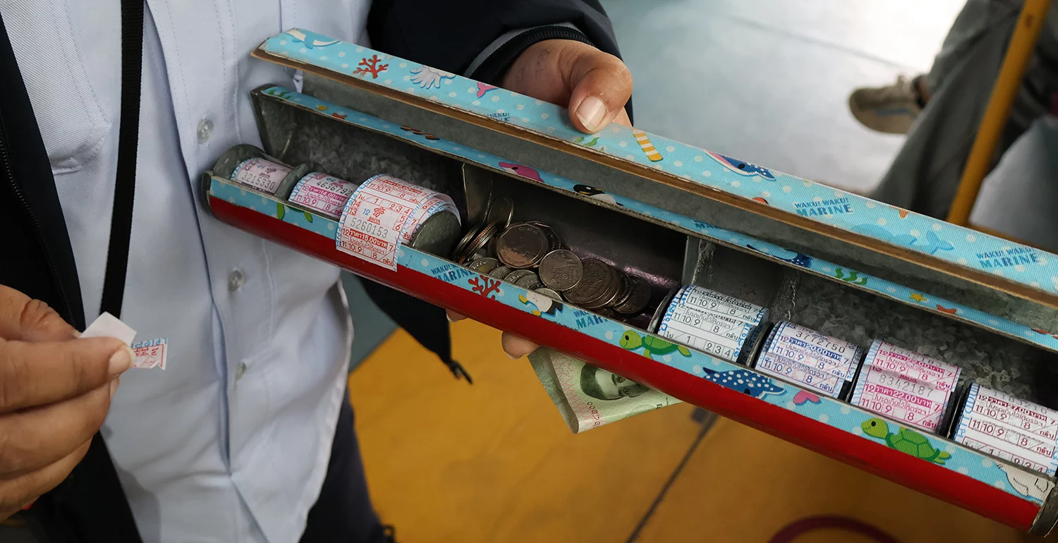 A person is holding a worn-looking box with different tickets in it.