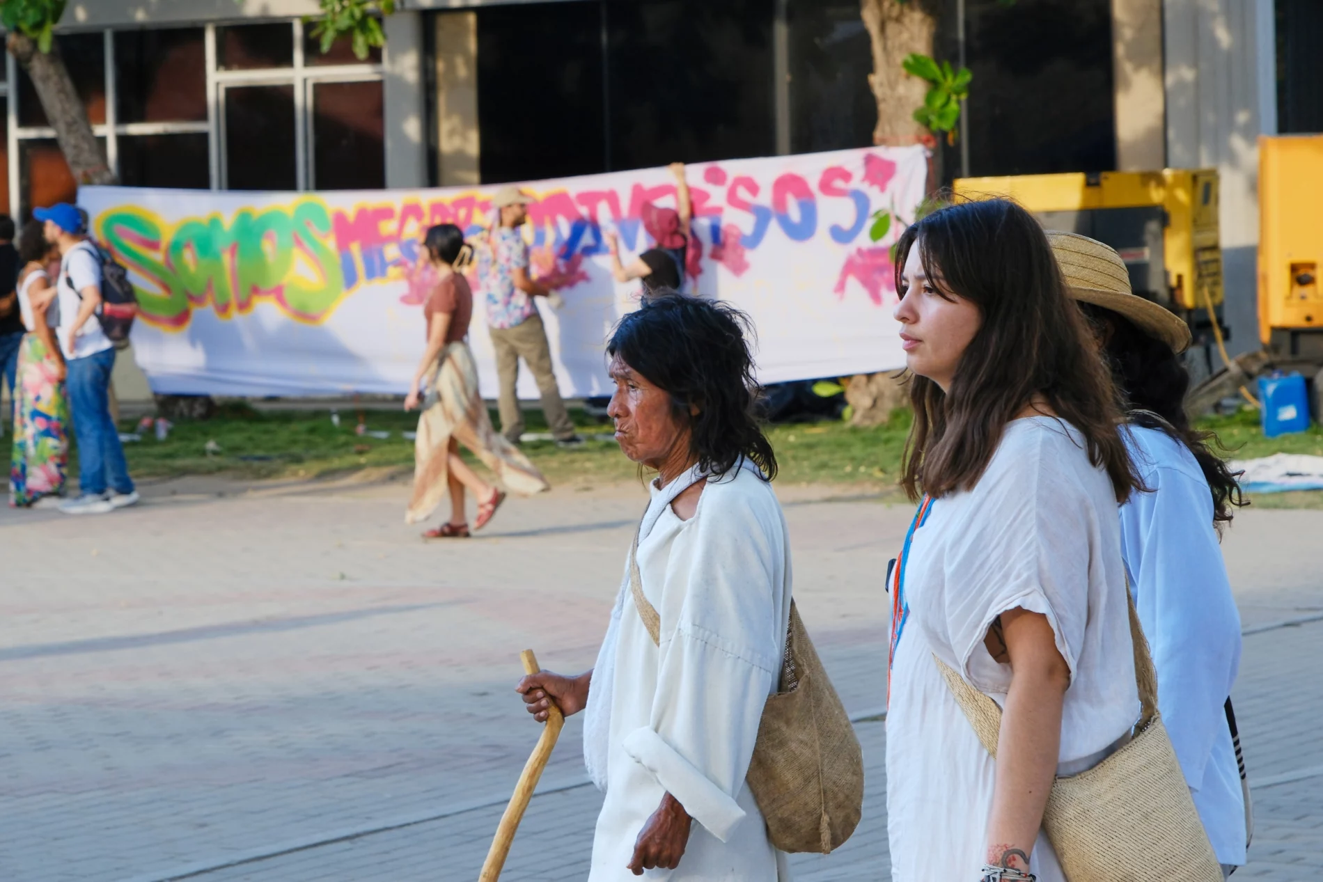 Three people dressed in white walk down a road at the Santa Marta First Conference on Transitioning Away from Fossil Fuels