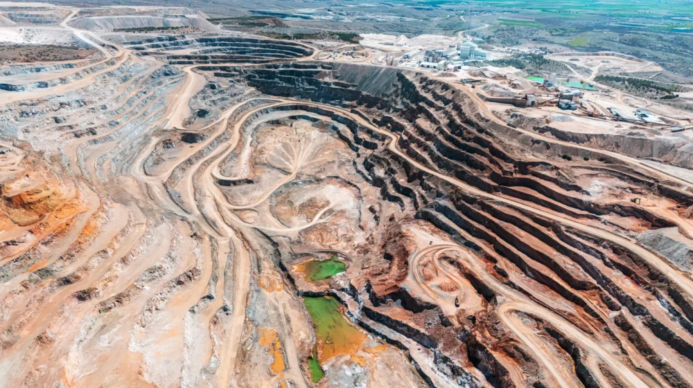 Aerial view of open-pit mining quarry with terraced excavation layers.