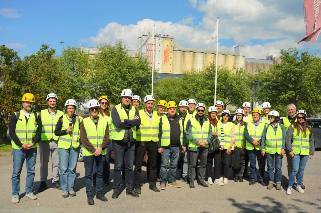 The group with helmets and yellow west outside a large biorefinery