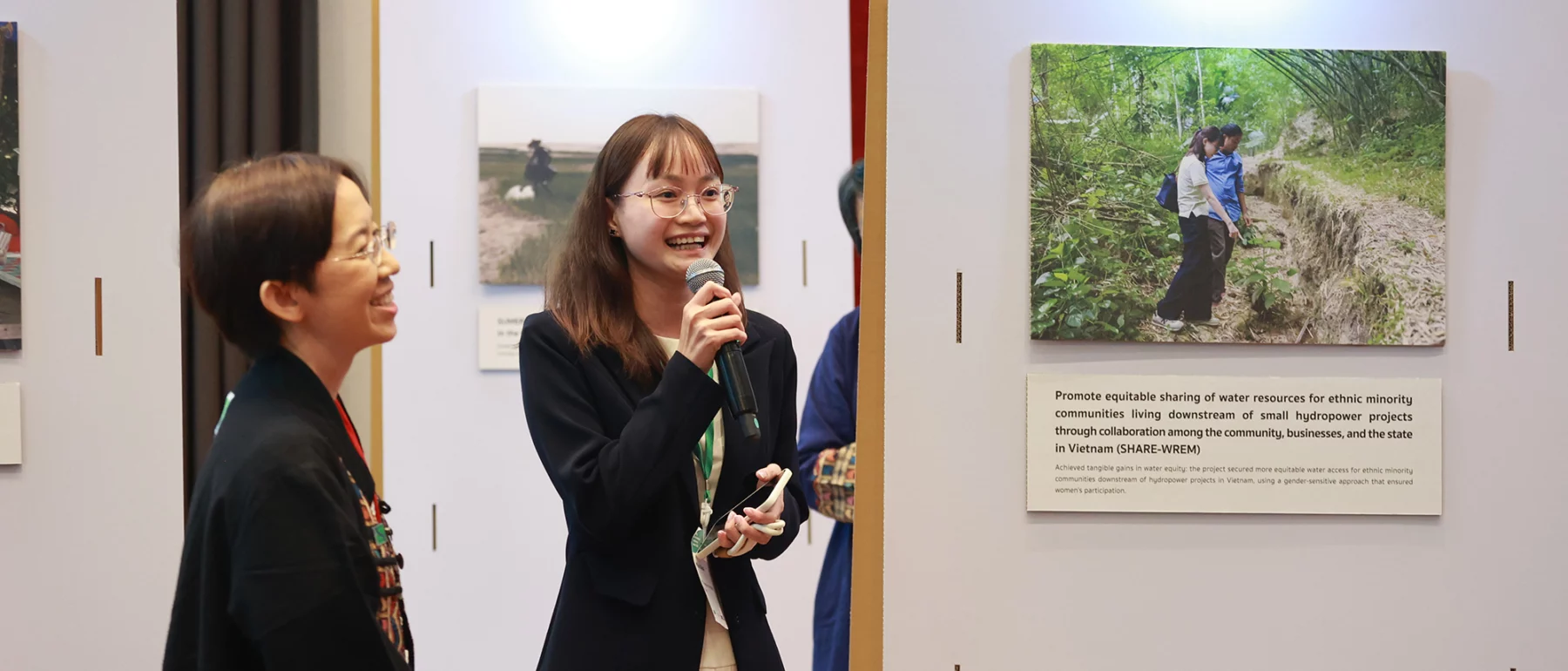 Person speaking into microphone in front of poster