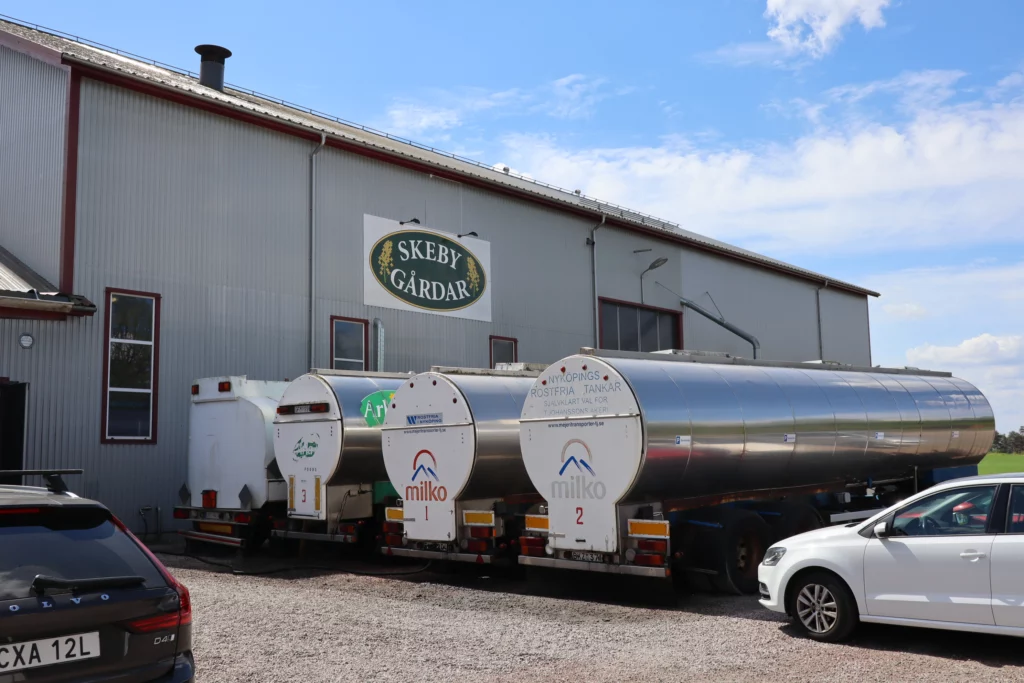 Visiting a rapeseed processing plant, here outside the plant next to large trucks.