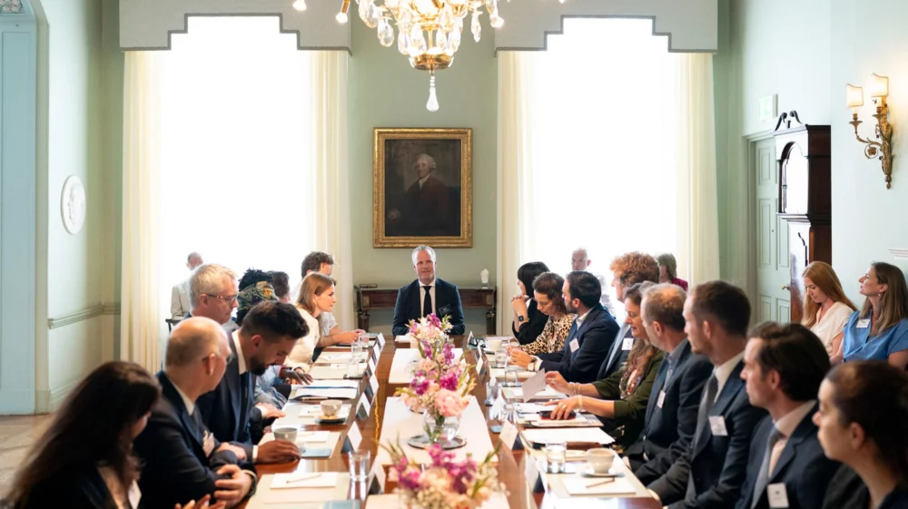 meeting room, people sit at long table