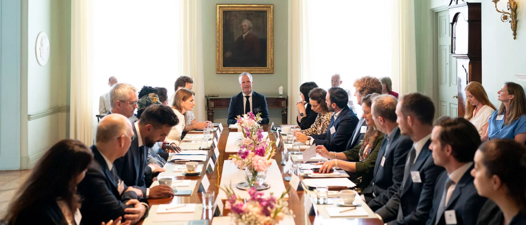 meeting room, people sit at long table