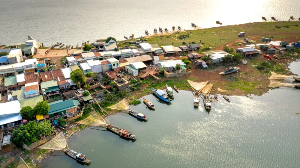 Scenic aerial view of a fishing village by the sea with boats and nets at sunset