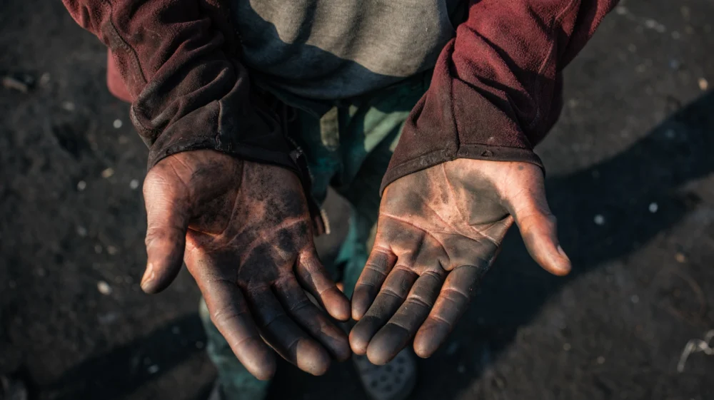 Peter Akpos's hands are covered in soot from the abattoir. Peter is a roaster who has worked for 18 years at AGIP abattoir in Port Harcourt, where cow skins are burned over open fires. Peter is exposed to thick smoke almost every day as part of his work. Despite the health risks, Peter continues this labor to support himself and his family, reflecting the daily realities of workers in the local meat processing industry. Rivers State, Nigeria. January 6 2026.