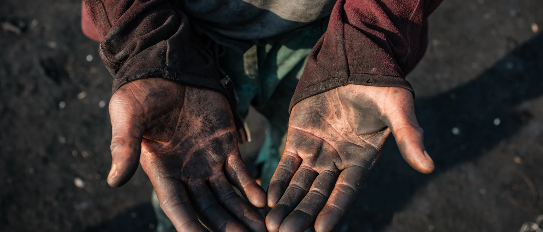 Peter Akpos's hands are covered in soot from the abattoir. Peter is a roaster who has worked for 18 years at AGIP abattoir in Port Harcourt, where cow skins are burned over open fires. Peter is exposed to thick smoke almost every day as part of his work. Despite the health risks, Peter continues this labor to support himself and his family, reflecting the daily realities of workers in the local meat processing industry. Rivers State, Nigeria. January 6 2026.