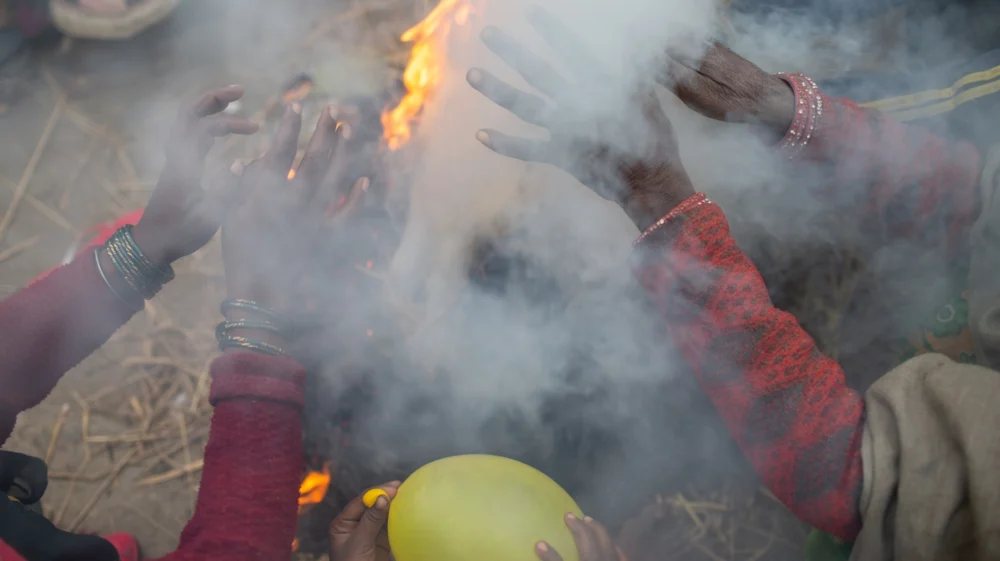 Women from Majhora Village, in the Mahottari District of Nepal, make themselves warm during the evening. There was not any sun for one week in the village due to the winter fog. During the winter fog people burn agriculture byproducts more and more to keep them warm. The more they burn the more black carbon is produced, prolonging the fog and increasing its impact on the people of the Terai region during the winter season.