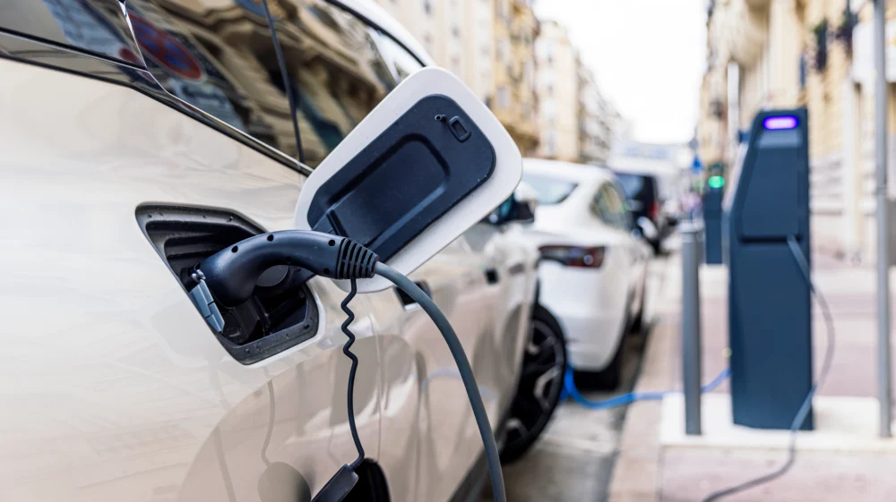 White electric car charging at the street