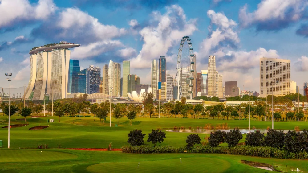Stunning view of Singapore's skyline including Marina Bay Sands and a lush golf course in the foreground