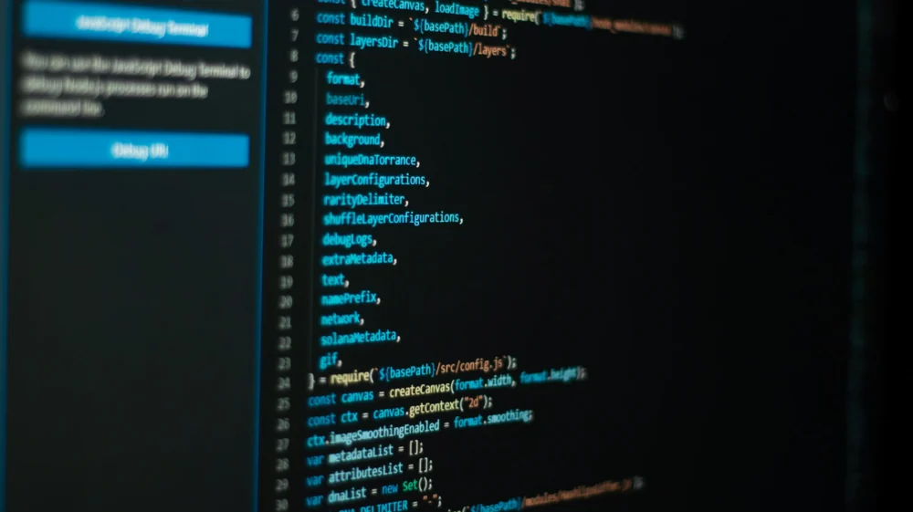 Close-up of a computer screen showing lines of code in blue and orange text on a dark background.