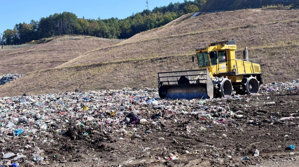 A landfill compactor spreads mixed household waste on an open landfill.